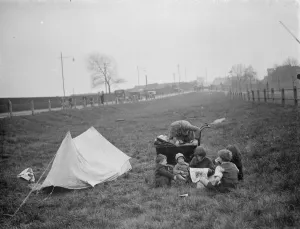 Children have a picnic on a bit of grass next to the road. 1938