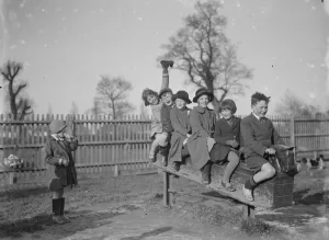 Boots Prints: Children play on a rocking horse in a playground. 1936