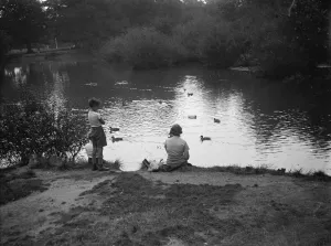 Children play with toy sailing boats in Dartford park. 24 August 1937