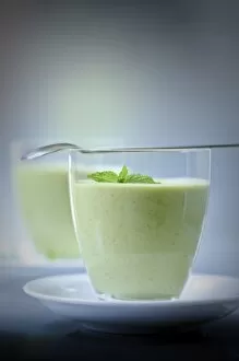 Savoury Collection: Chilled soup of fresh garden peas and courgettes in small glasses on white saucers