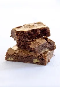 Cooking Prints: Three chocolate brownies stacked on white background credit: Marie-Louise Avery