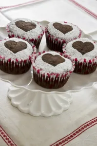 Sweet Prints: Five chocolate muffins decorated with icing sugar in heart shape on white cake stand credit