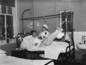 Christmas at the County Hospital in Dartford, Kent. A nurse is helping a patient smoke