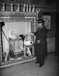 The cinema usher at the Commodore Theatre, Orpington standing by a display of