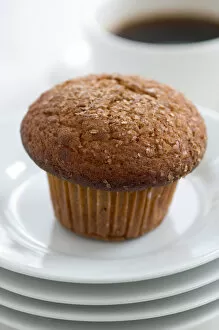 Bake Off Inspiration Collection: Cinnamon bran muffin on stack of white plates with cup of black coffee credit