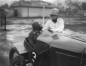 A contrast in face protectors for women speedway racers. Two famous women motorists