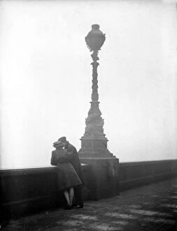 Romance Collection: Couple arm in arm leaning over bridge in London in fog 1940s love couple romance