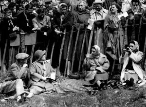 Sport Prints: The Crowd Watch the Queen Filming Only a narrow fence separates the crowd from members