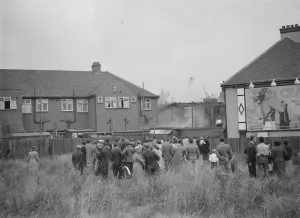Crowds gather as firemen attempt to put out fires in a parade of shops in Welling, Kent