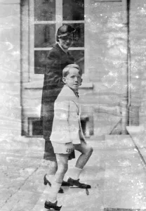 A Crown Prince comes home from school. Crown Prince Baudoin of Belgium clinging