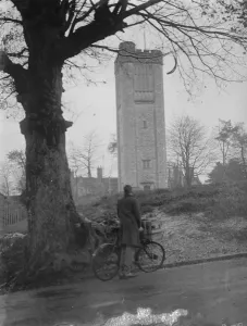 Bike Prints: Cyclist looks at a water tower. 1935