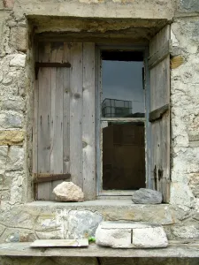Vacation Prints: Deep set window in stone building with old weathered shutters held in place with a rock