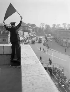 Public Transport Prints: Derby Day, Epsom. A Bus Official controlling the Derby Day buses, taking