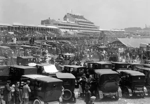 Cars Prints: Derby Day at Epsom Racecourse. Looking across the parked cars to the grandstands