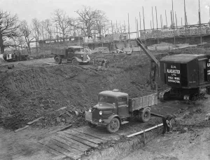 Digger clears the land and puts soil into the back of Bedford truck on the site of