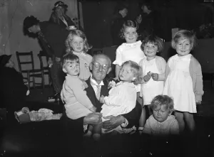 Doctor Prints: Dr Jowett with his arms full at the Dartford baby show. 25 October 1935