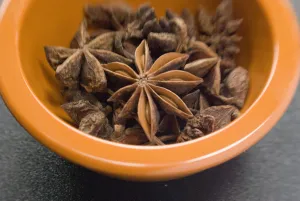 Dried Star anise fruits in small bowl. Also known as star aniseed, badiane or Chinese