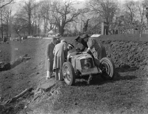 Driver escapes in 100 miles an hour crash at British Empire trophy races. Wel Handley