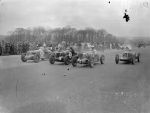 Driver escapes in 100 miles an hour crash at British Empire trophy races. Wel Handley