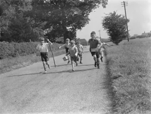 Evacuated children in Wye, Kent, running down a country road. 1939 / 40