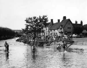 Youth Prints: Families play in the flood water in Eynsford, Kent. Some of the children paddle others