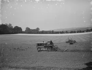 Machinery Prints: A farmer and his tank track tractor, harrow a field 1936