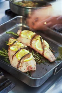 Preparation Prints: Fillets of monkfish in pan ready to be roasted on bed of rosemary with lemon