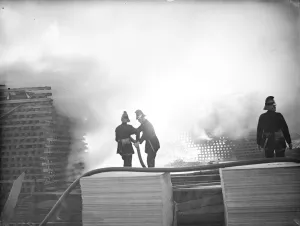 Smoke Prints: Firemen train their hoses on the flames at the timber fire at Welling in Kent