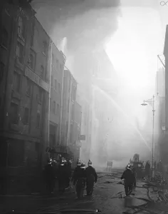 London Life Prints: Firemen wallow in molten rubber as warehouse blazes still. Firemen wading through