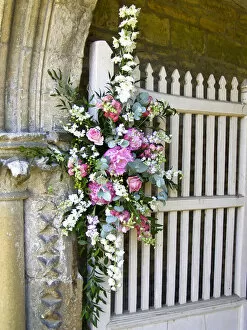 Summer Collection: Flower arrangement decorating entrance to country church for summer wedding. credit