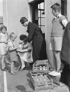 Free milk for children on holiday in Crayford, Kent. A woman is collecting