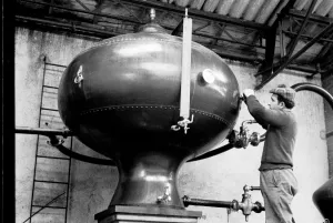 Alcohol Prints: French distillery worker checking the still at a brandy distillery in Cognac, Charente