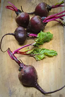 Board Prints: Whole fresh raw beetroots on wooden board credit: Marie-Louise Avery / thePictureKitchen