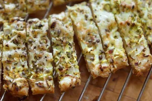 Freshly baked cheese straws cooling on rack, made with grated courgette and grated