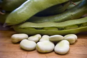 Vegetable Collection: Freshly podded pale green broad beans on wooden surface credit: Marie-Louise Avery