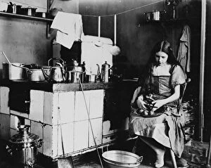 Pots Collection: A girl peeling apples in a kitchen. c. 1908