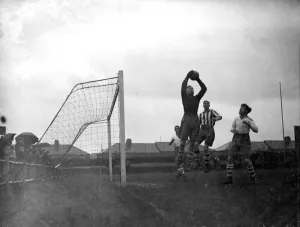 Keeper Prints: The goalkeeper makes a save at the Dartford V Enfield football match. 10 November 1934