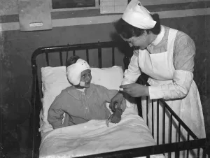 Ward Prints: Gravesend Hospital in Kent. Nurse tending to a child patient. 1939