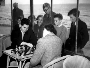 Group Prints: Hastings, Sussex: A group of youngsters watch through the window of the Sun Lounge
