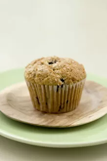Green Collection: Healthy bran and raisin muffin on small wooden plate on green platter credit: Marie-Louise