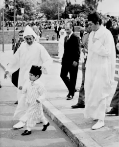 HM King Hassan II of Morocco adjusts the Fez worn by his young son Prince Sidi Mohammed