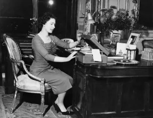 Desk Prints: HM Queen Elizabeth II at her desk in Buckingham Palace as she opens one of the boxes