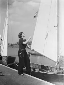 Hoisting the flag!. Yachting girl, Miss Peggy Masters, wasting the burgee (pennant
