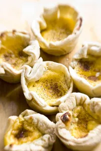 Home made portuguese style custard tarts with confectioners custard and puff pastry credit