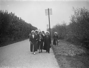 Hop pickers walk along a country lane. 1935