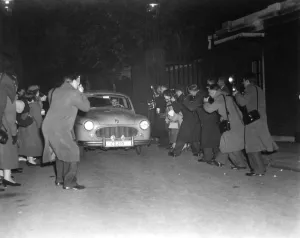 A host of press photographers descend upon the car belonging to Group Captain Peter