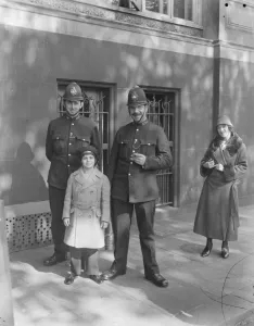 Jackie Coogan in safe custody. Jackie Coogan with two policemen, who saved him