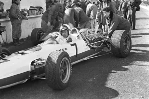 Japanese mechanic pushing John Surtees Honda car during testing at Brands Hatch
