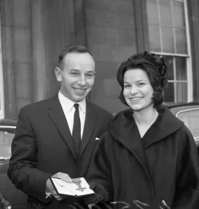 Award Prints: John Surtees with Miss Patricia Burke outside Buckingham Palace after he collected