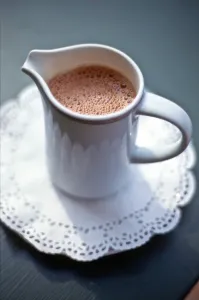 Pretty Prints: Jug of hot drinking chocolate on white paper lace doiley credit: Marie-Louise Avery